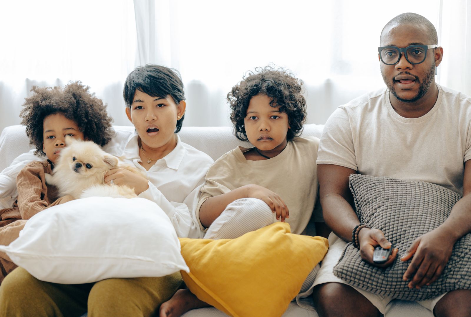 Family watching television together in a living room while choosing simultaneous IPTV connections